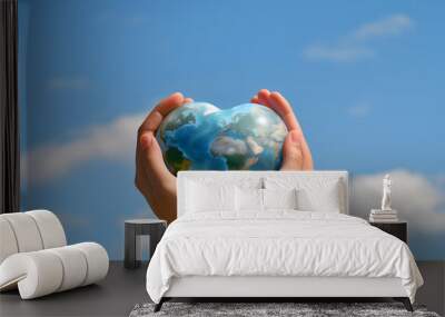 Earth day concept. hand hold Earth in Heart shape on sky background Wall mural