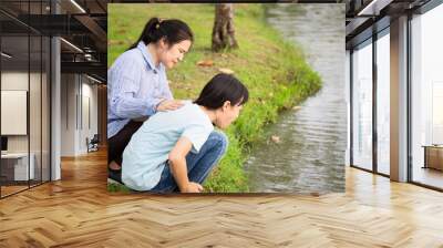 Asian child girl about to throw up,vomit,puke retch barf,feel sick from indigestion or food poisoning,stomach upset virus,daughter with woman or mother helping,care her in outdoor park,health care  Wall mural