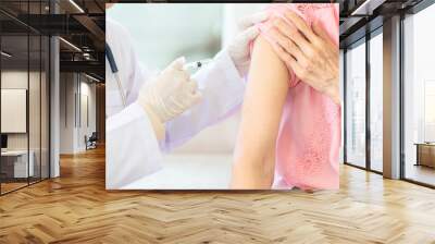 Close up,asian female doctor with syringe doing injection vaccine,flu,influenza in the shoulder of senior woman, nurse injecting,vaccinating elderly patient,vaccination,medicine,health care concept Wall mural