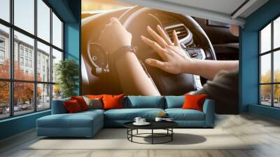 Closeup hands of asian woman,hand pushing on steering wheel honking horn, on the road,female driver concept Wall mural