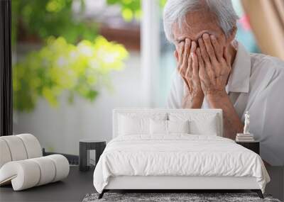 Depressed senior woman covering face with hands,Lonely old people crying alone at home,loneliness,hopelessness,dejection,Sad elderly patient with depression,mental health problems,depressive illness Wall mural