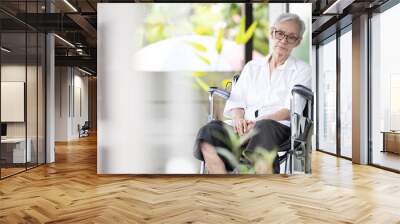 Sad and depressed asian senior woman sitting alone in wheelchair with head down feel lonely and bored,disabled old elderly with loneliness waiting for her family to come visit her at the nursing home Wall mural