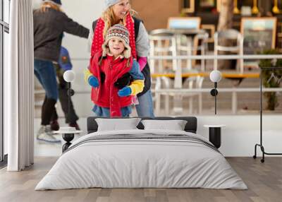 a mother helps her son learn to ice-skate Wall mural