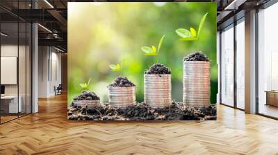 Growing plants on coins stacked on green blurred backgrounds, Growing money, Plant on coins, Finance and investment concept. Wall mural