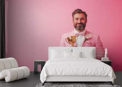 Smart businessman holding golden trophy in have in victory pose studio shot on pink background . Wall mural