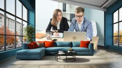 Business, team work and people concept - Serious man and attractive woman working at project in office Wall mural