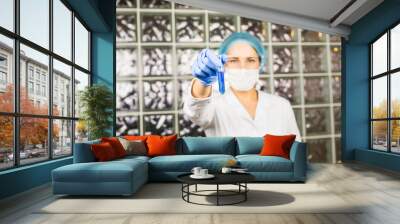 Close-up of glass tube with blue fluid in nurse hand during medical test Wall mural