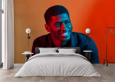 Face African American stylish man posing on the blue and red neon light background. Wall mural