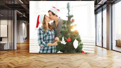 family, x-mas, winter holidays and people concept - love young couple decorating christmas tree at home Wall mural