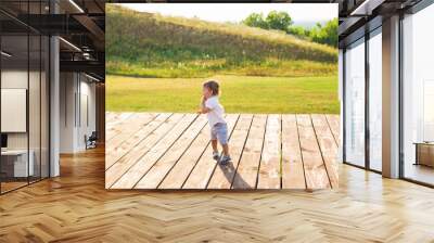 Happy laughing baby boy playing on summer outdoor Wall mural