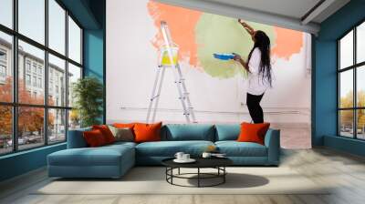 Happy smiling african american woman painting interior wall of new house. Redecoration, renovation, apartment repair and refreshment concept. Wall mural