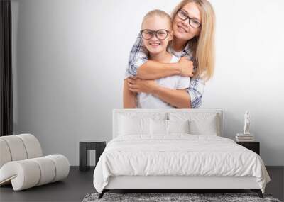 Happy young mother and laughing kid in fashion glasses have fun on white background Wall mural