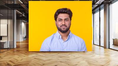 Indian handsome man wearing blue shirt on yellow background Wall mural