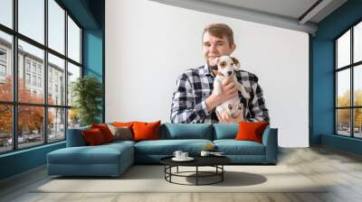 People, pet and dog concept - Smiling man over white background holding puppy Jack Russell Terrier Wall mural