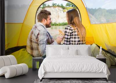 People, tourism and nature concept - Cute couple sitting with a cat in yellow tent Wall mural