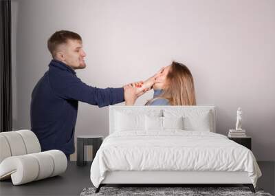 People and abuse concept - Portrait of angry young man try to hit the woman Wall mural