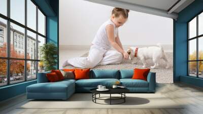 Pets and animal concept - Child girl playing with puppy Jack Russell Terrier Wall mural