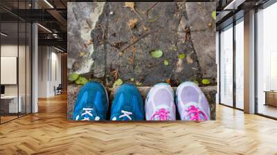 top view of a two pairs of sneakers shoes on paving stone Wall mural