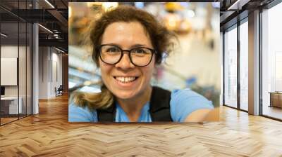 Video call portrait of excited cheerful smiling woman in spectacles taking selfie photo. Selfie and blogger concept Wall mural