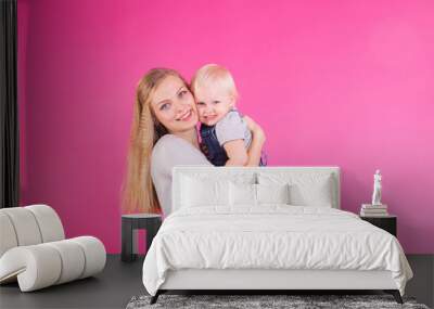 young mother and daughter having fun together on pink background Wall mural