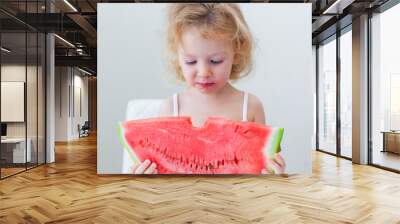 cute little baby girl eating watermelon slice on light background Wall mural