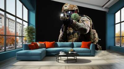 Military man in camouflage and in full combat readiness, wearing a helmet and gas mask, aims through a collimator sight directly at the enemy using chemical weapons isolated on black background Wall mural