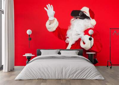 Santa Claus wearing virtual reality goggles, on a red background. Christmas Wall mural