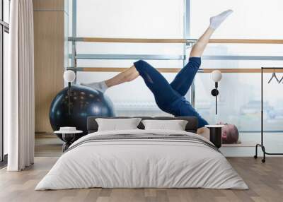 Young girl working out at the gym with a ball Wall mural