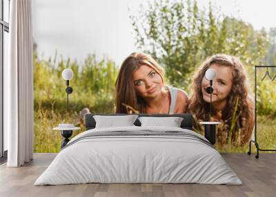 two girlfriends lying down on grass Wall mural