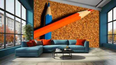 Orange and blue pencils on corkboard from above is close Wall mural