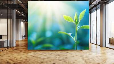 A close-up of a growing plant bathed in soft sunlight, with a blurred blue sky behind, representing hope and renewal. Wall mural