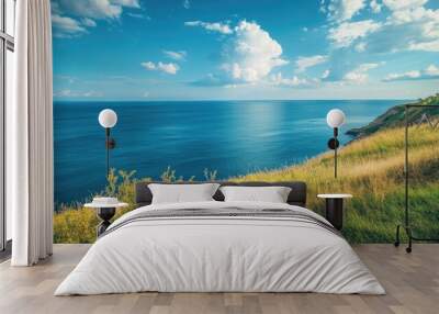 Coastal hillside overlooking the vast blue ocean, with the sky filled with soft clouds and plenty of copy space. Wall mural