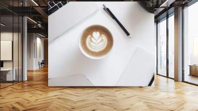 Laptop, coffee, and a notepad neatly arranged on a desk, symbolizing efficient process management, productivity, and seamless workflow in a modern office Wall mural