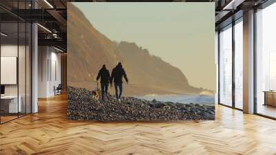 Couple walking dog on the pebble beach near town of Seaton, Devon Wall mural