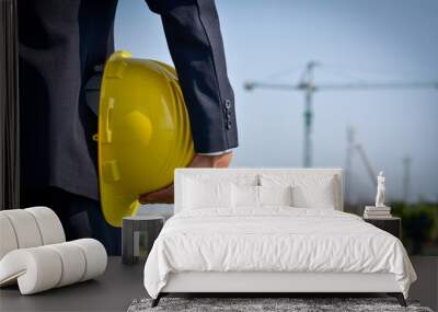 A yellow safety helmet in the hands of a construction businessman Wall mural