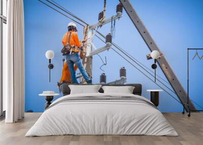 Electricians are climbing on electric poles to install and repair power lines. Wall mural