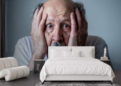 Close up of scared and shocked senior man gesturing in fear with hands and face Wall mural