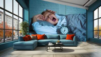 Cute girl feeling exhausted early in the morning having trouble getting up in Child insomnia concept Wall mural