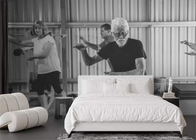 Group of elderly senior people practicing Tai chi class in age care gym facilities. Wall mural