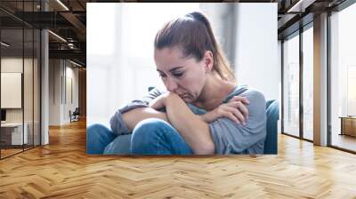 Young attractive latin woman lying at home living room couch feeling sad tired and worried suffering depression in mental health, problems and broken heart concept. Wall mural