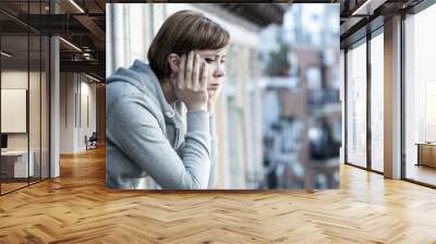 young attractive unhappy depressed lonely woman looking sad on the balcony at home Wall mural