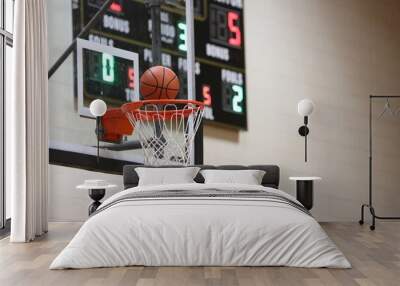 Basketball at the hoop with black scoreboard in background  Wall mural