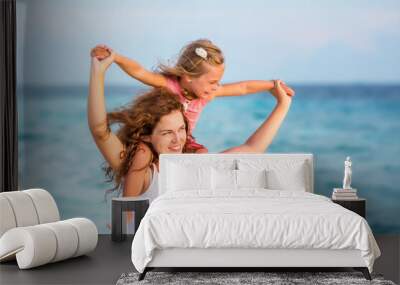 Happy mother and little daughter having fun on beach on Maldives at summer vacation. Family on the beach concept. Wall mural