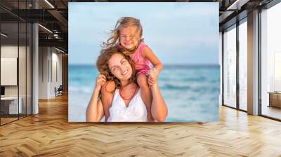 Portrait of happy mother and little daughter on sunny beach on Maldives at summer vacation Wall mural