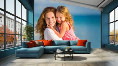 Portrait of happy mother and little daughter on sunny beach on Maldives at summer vacation Wall mural