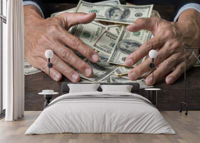 Man hands sweeping money,business concept.
Lucky man winning  lots of us dollar from gambling,with smiling face and black background. Wall mural