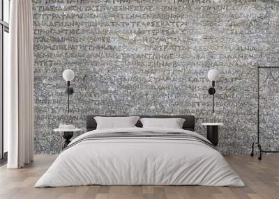 Ancient Greek writing background, Antique stone inscription. Old script text close-up. Gray wall with historic letters. Vintage texture with words from past civilization. Wall mural