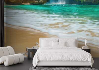 Tropical beach with sand and waterfall in distance, beautiful sea shell or conch on shore in paradise. Concept of travel, vacation, resort and nature Wall mural