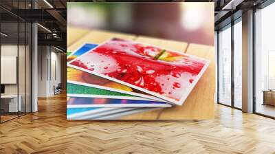 stack of color photo pictures on wooden table outdoors Wall mural