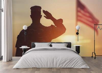 Silhouette of a soldier saluting in front of an American flag during sunset, symbolizing patriotism and military service. Wall mural